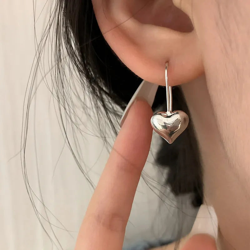Silver tone heart-shaped earrings with glossy finish and Korean style design