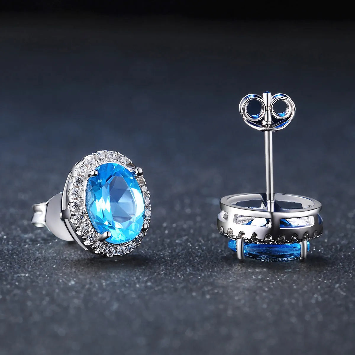 Four-piece 925 Sterling Silver geometric jewellery set with blue topaz gems, showing earrings, ring, pendant, and necklace.