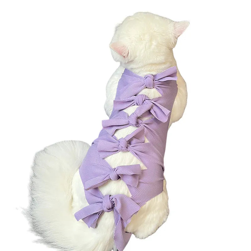 Cat wearing a pink lace-up polyester sterilisation suit after surgery, showing the adjustable tie closure.