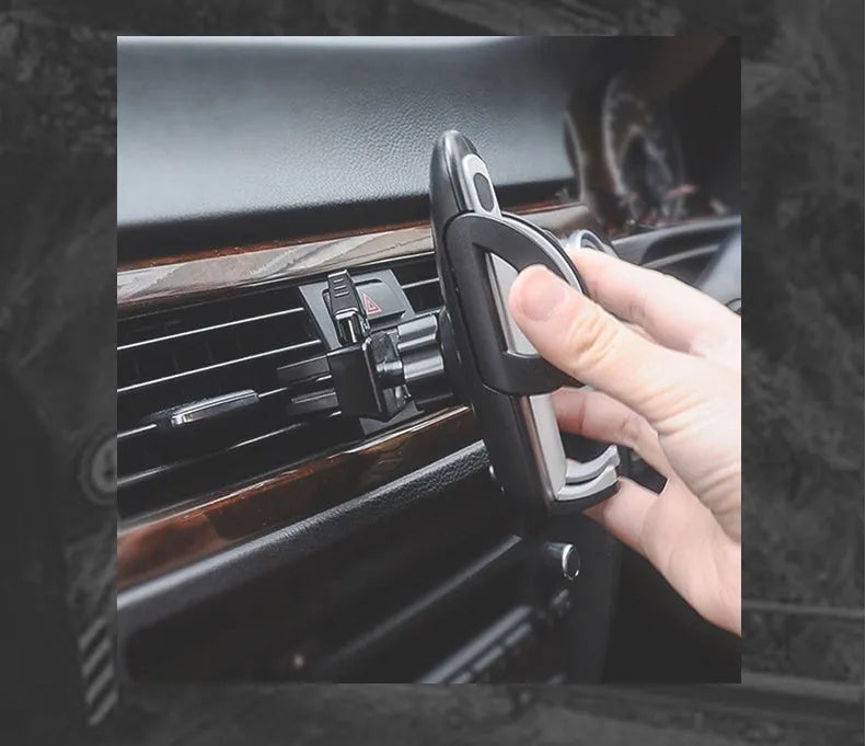 Black plastic universal mobile phone holder attached to a car air vent.