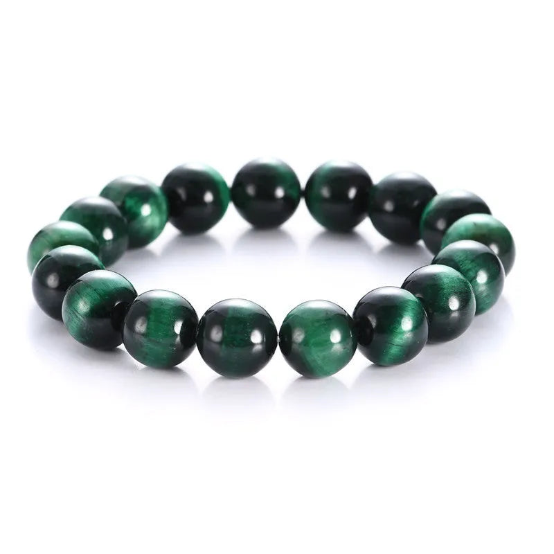 Polished green tiger eye stone bead bracelet with geometric beads on a wrist.