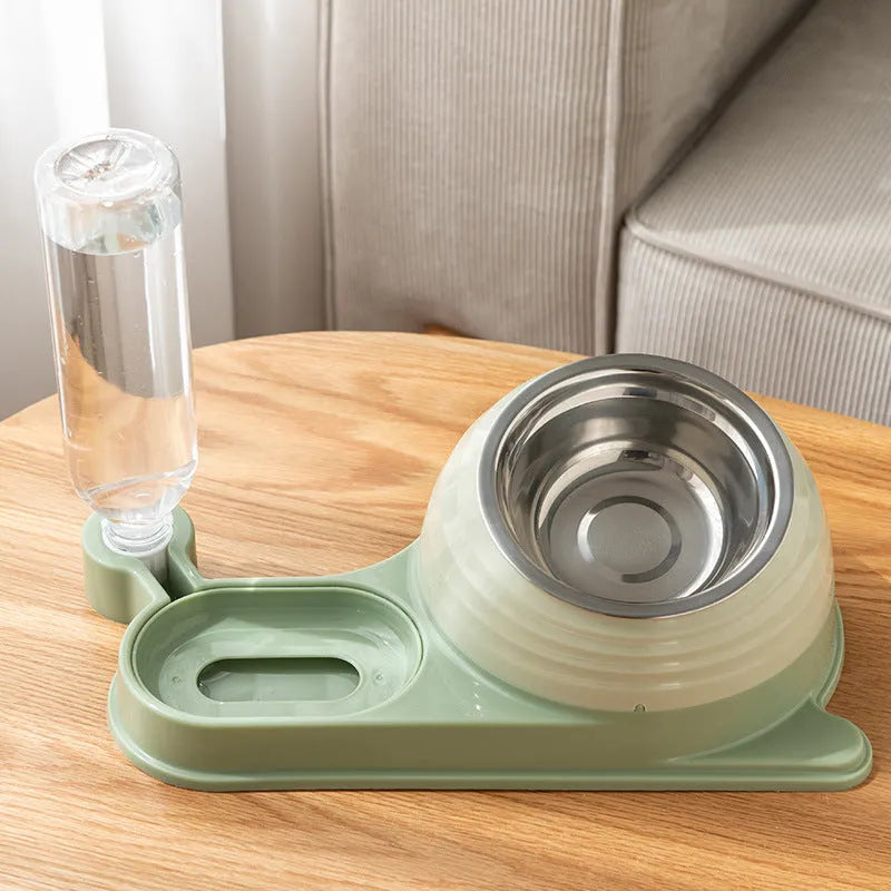 Brown elevated cat bowl with attached water dispenser bottle on a wooden floor.