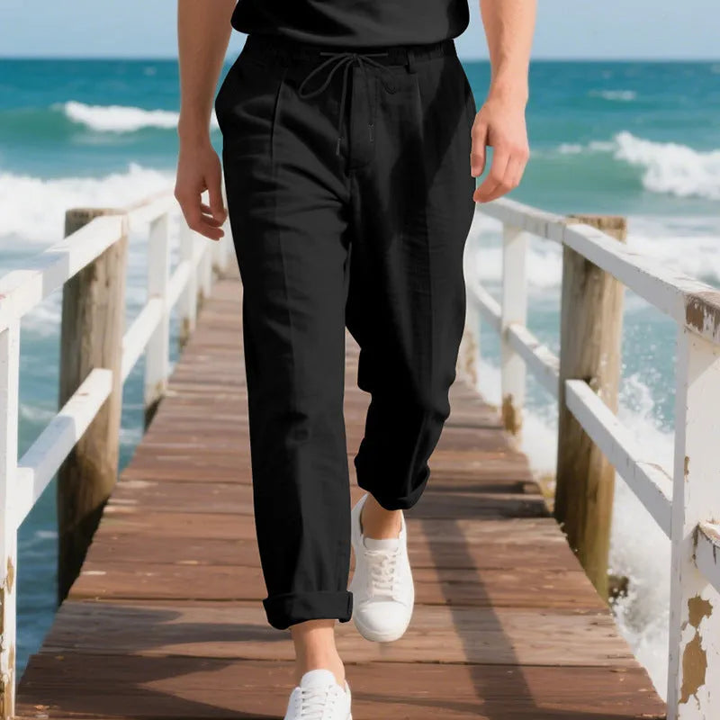 Men's loose-fit straight-leg linen trousers in light khaki colour with a drawstring waist.
