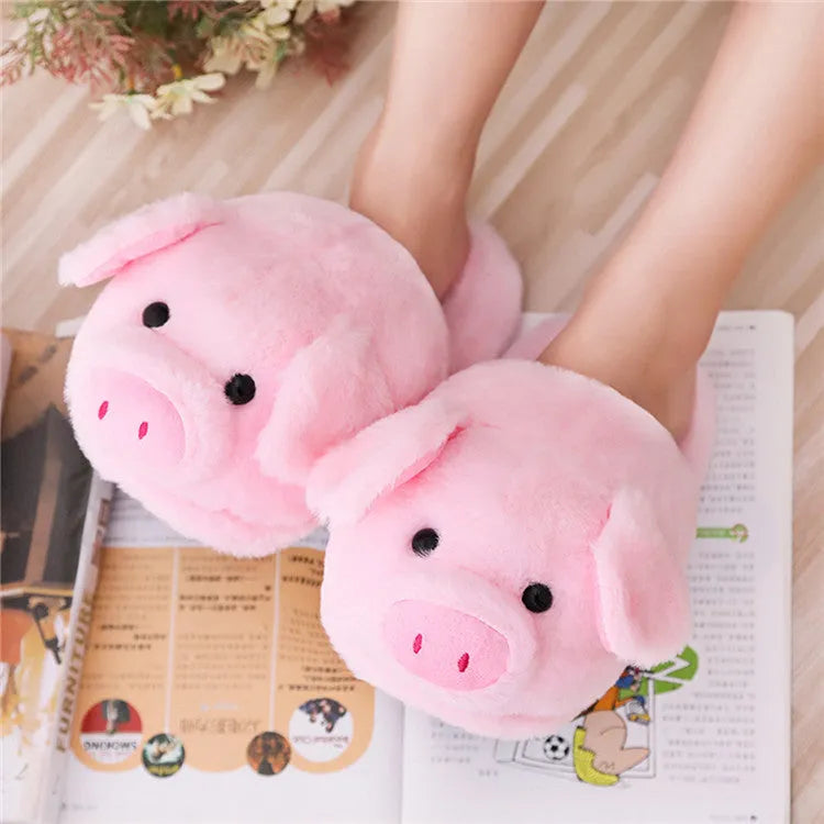 Pink pig-shaped plush slippers for adults on a white background.
