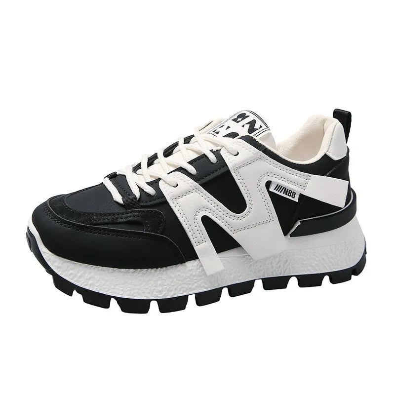 White and black unisex low-top sneakers with round toe and front lace-up on rubber sole