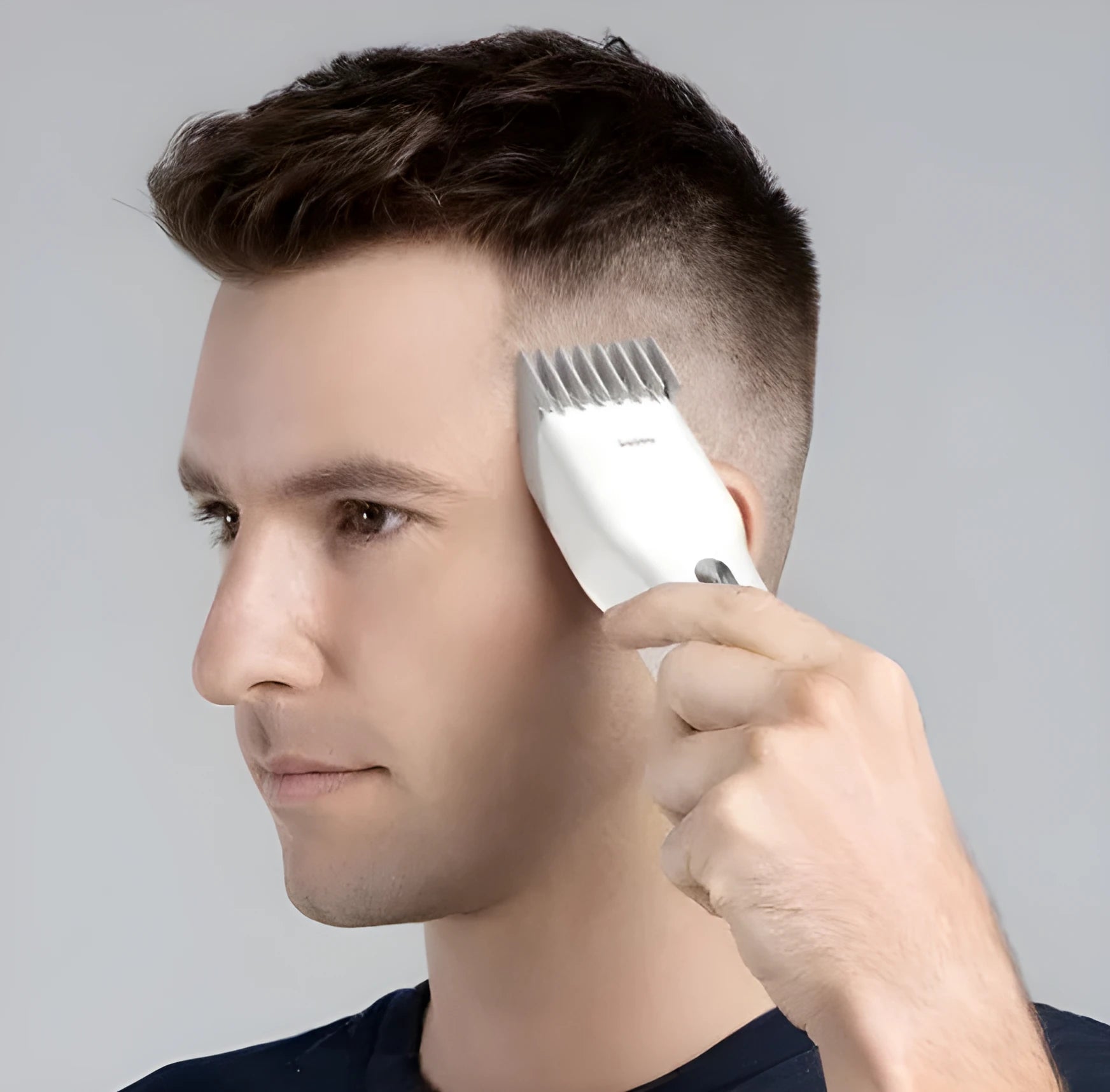 Black and white cordless electric hair clipper with ceramic cutter head and adjustable comb.
