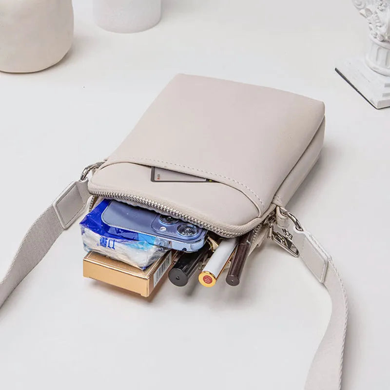 Solid colour small crossbody mobile phone bag in beige, showing front view and adjustable strap.