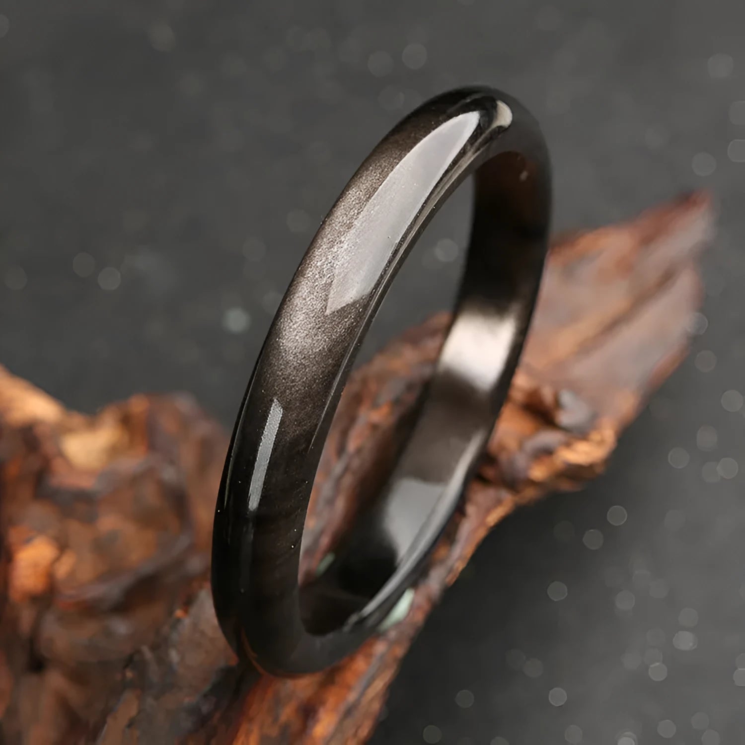 Natural silver stone cat's eye bracelet in obsidian style with ethnic geometric design on wrist.
