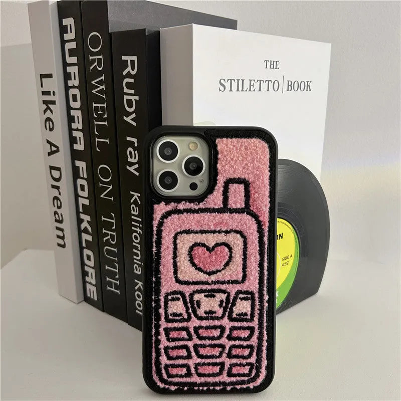 Pink TPU iPhone case with a towel-embroidered pattern, shown fitting an iPhone model.