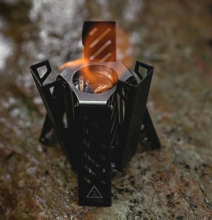 Hexagon-shaped foldable alcohol stove for camping shown in black and silver colour options