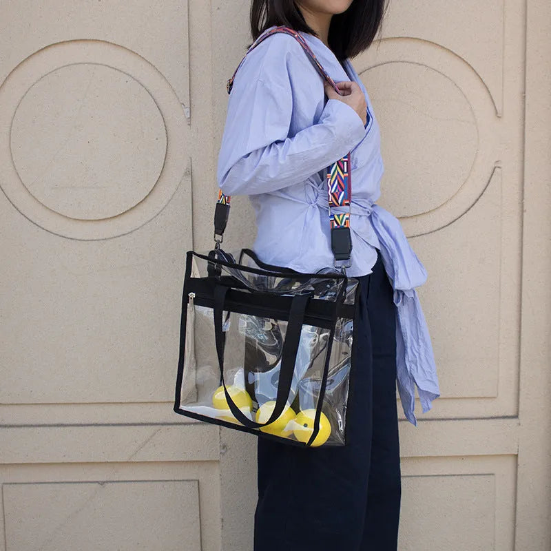 Women's transparent PVC crossbody messenger bag showing front 3D pocket and double shoulder straps.