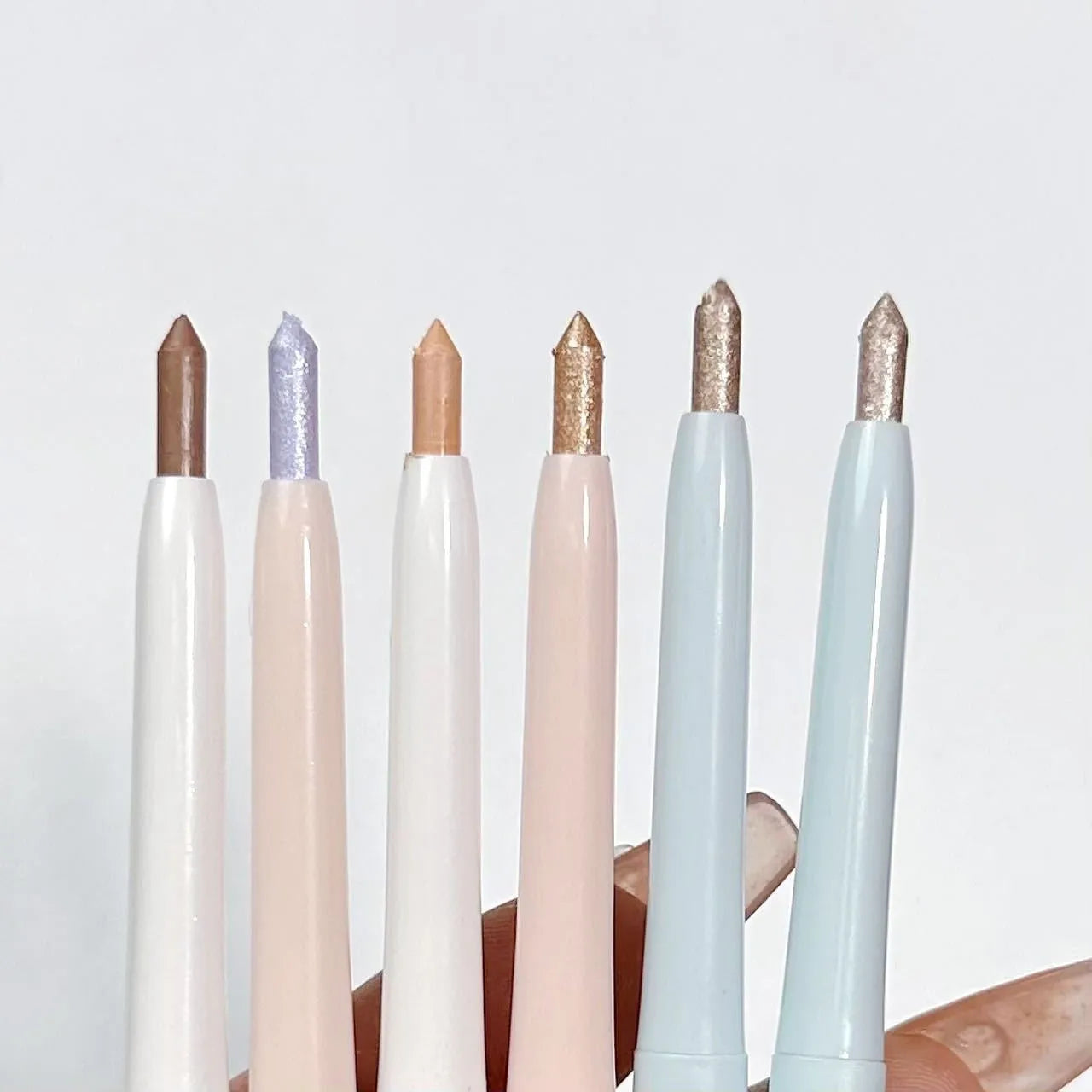 Waterproof non-smudge eye shadow pen in gold and purple shades for highlighting and brightening.