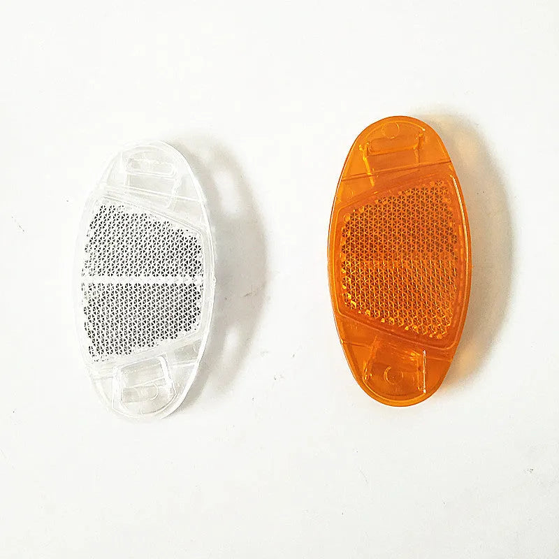 White and yellow plastic bicycle spoke reflectors measuring 7.2cm by 3.5cm for safety visibility