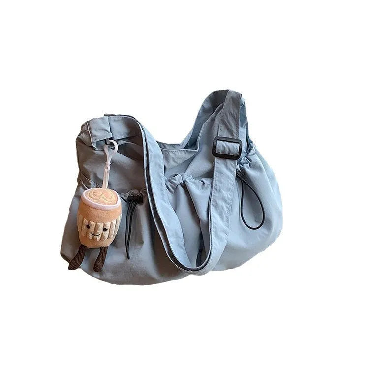 Ultra-light pleated foldable crossbody bag in soft polyester fabric, shown in green with split pockets.