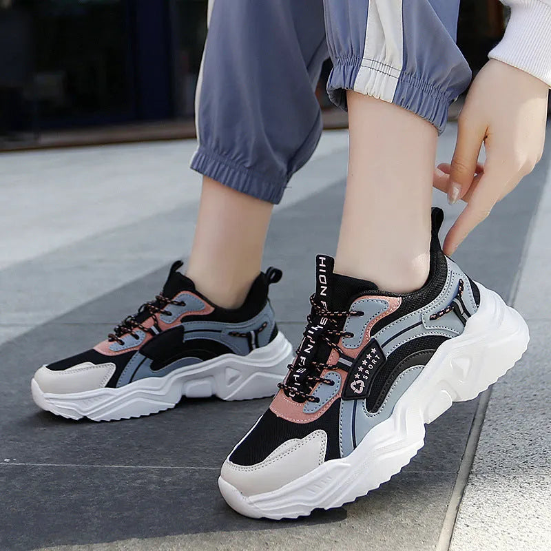 Women's white thick-soled casual sports shoes with mesh upper and buckle detail.