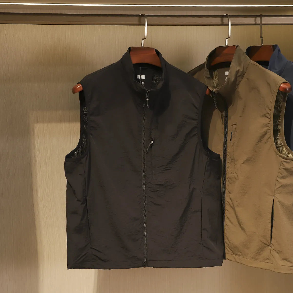 Men's straight cut nylon vest in army green with side seam pockets.