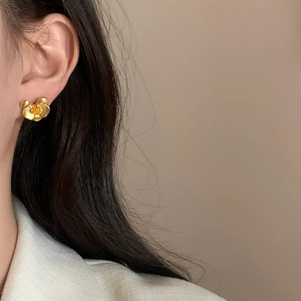 A pair of retro-style copper flower earrings with petal details in a gold electroplated finish.