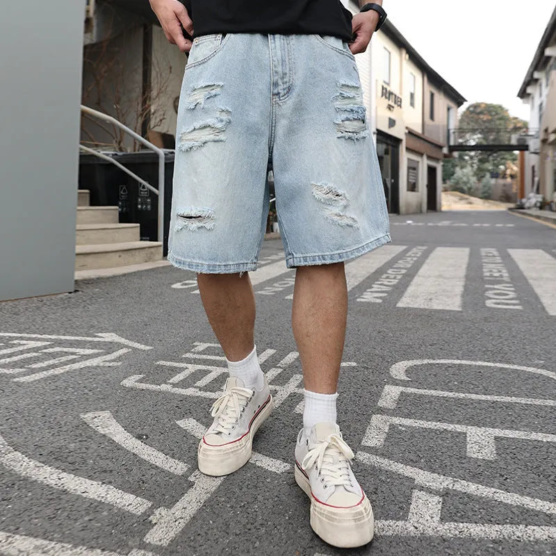 Light blue ripped denim shorts with a loose, straight leg fit and distressed detailing.