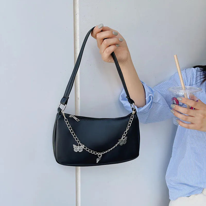 Retro-style square crossbody handbag with a butterfly clasp on its chain strap.