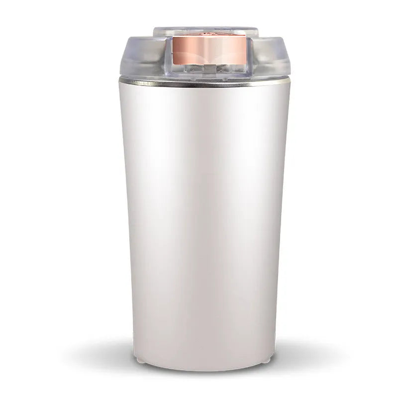 Blue mini electric grain and spice grinder with stainless steel blade on a kitchen worktop
