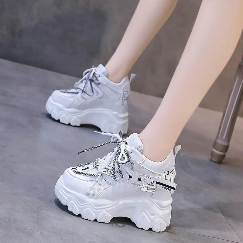 White women's mesh platform tennis shoes with cross strap and a thick rubber sole.