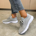 Women's low-top running shoes with mesh lining and Flyknit upper in creamy white, grey, or orange colours