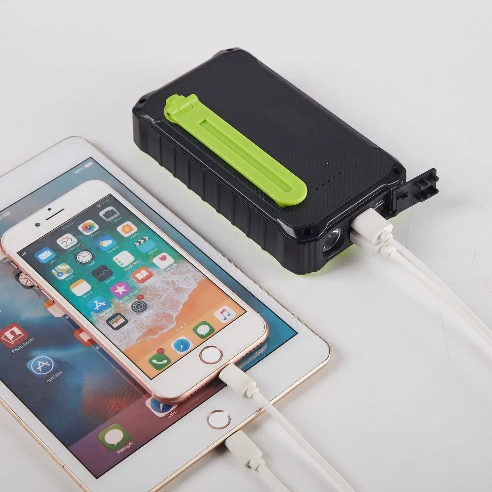 Orange and green hand solar power bank with solar panel, hand crank, dual USB ports, and LED light