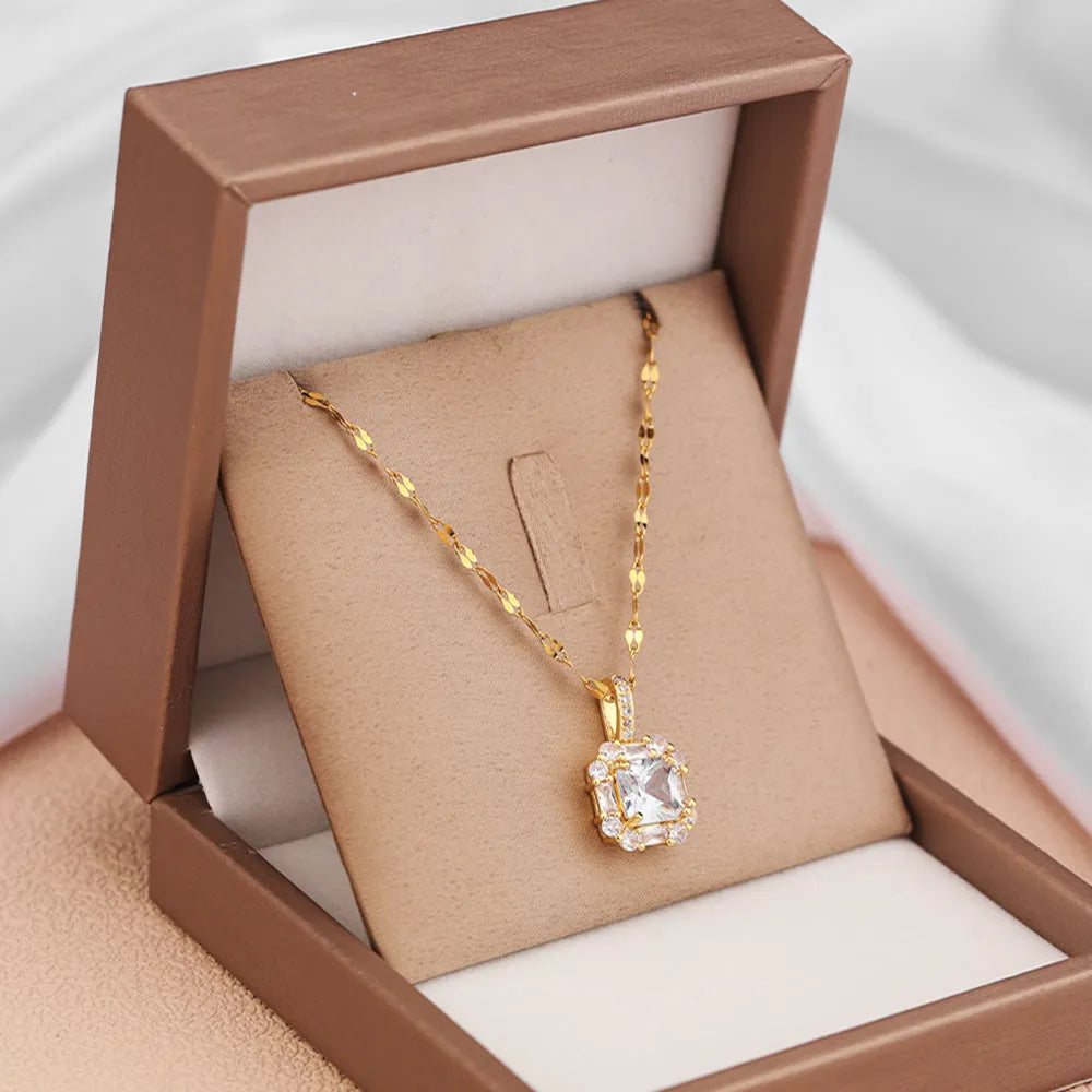 Gold tone geometric quadrilateral pendant necklace with inlaid zircon stones on a water wave chain.