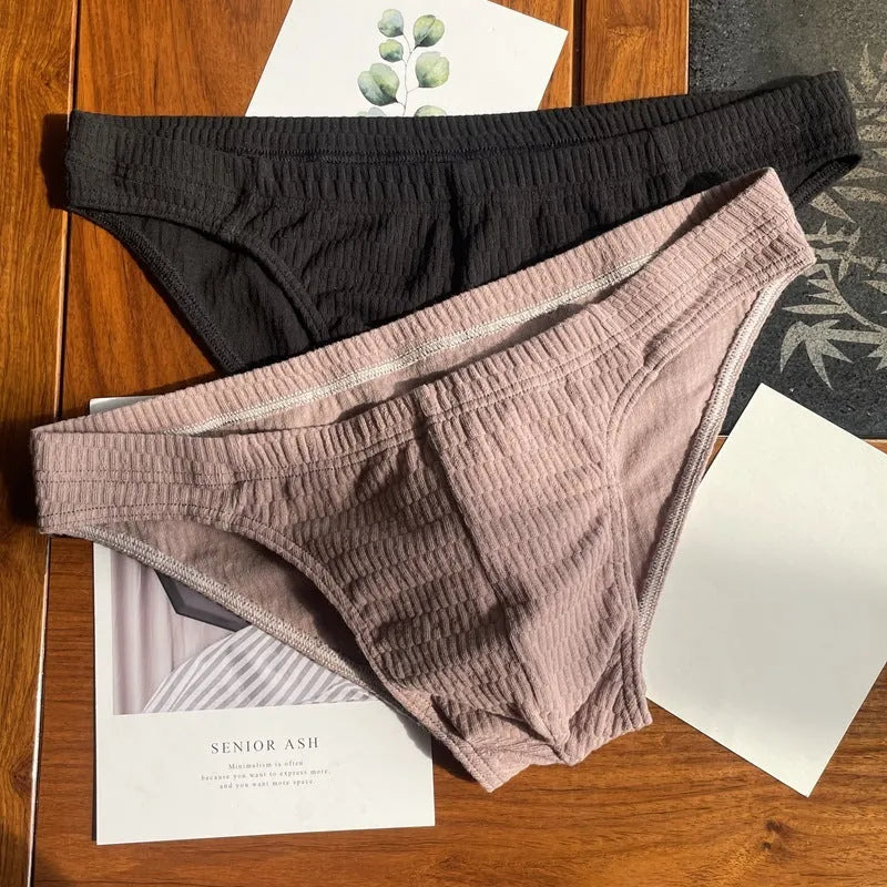Men's solid colour cotton triangle briefs with a mid-waist waistband on a white background.