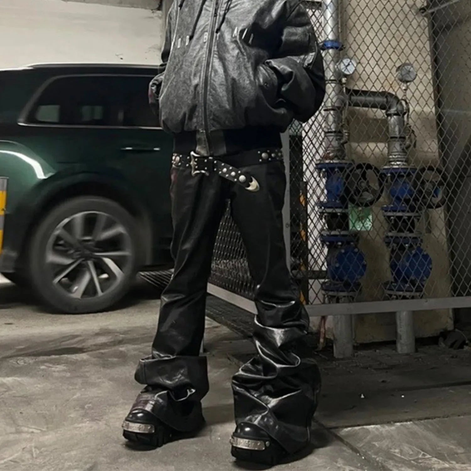 Black coated patent leather skinny jeans in a straight-leg cut on a model.