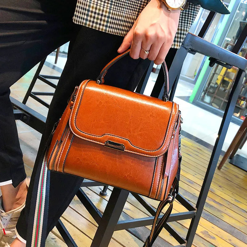 Women's brown genuine leather retro messenger bag with shoulder strap showing organised interior pockets.