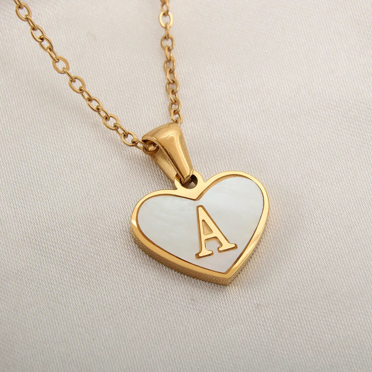 Gold plated heart-shaped personalised necklace with white shell charm on an adjustable chain.