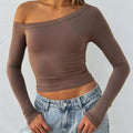 Women's solid colour knitted cardigan with cross shoulder straps and long sleeves.