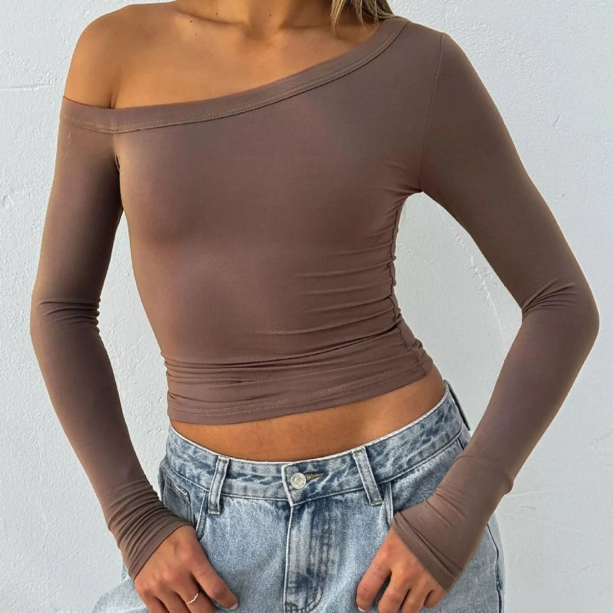 Women's solid colour knitted cardigan with cross shoulder straps and long sleeves.