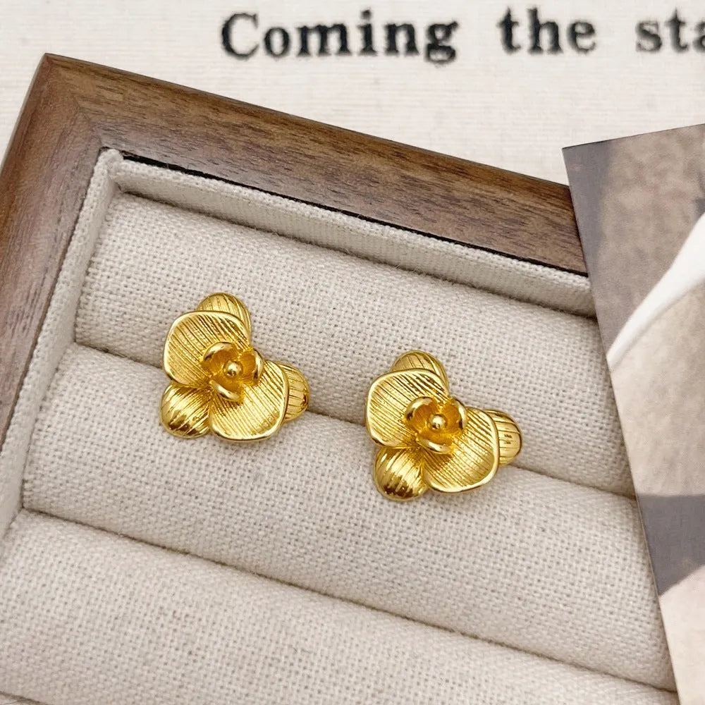 A pair of retro-style copper flower earrings with petal details in a gold electroplated finish.