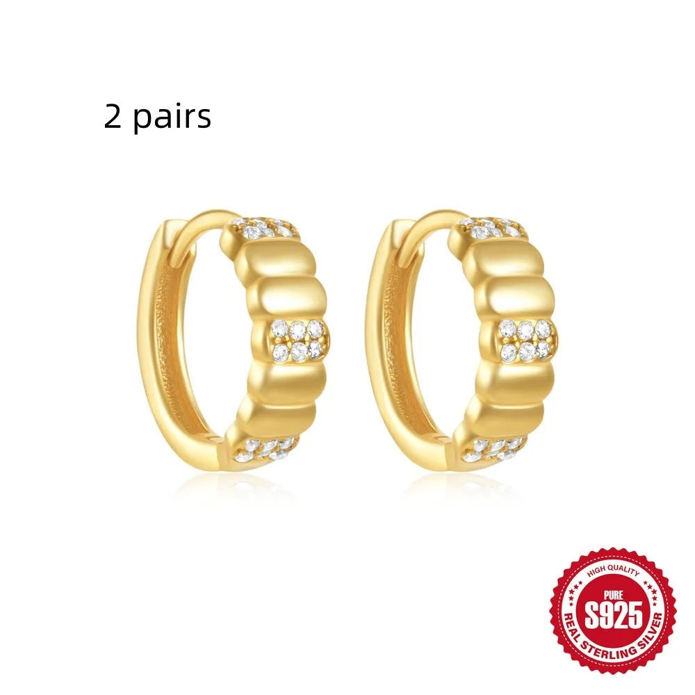 Sterling silver geometric stud earrings with a small round shape and classic diamond detail on a white background.