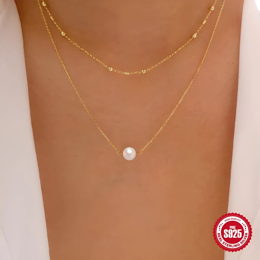 S925 sterling silver double layer necklace with twin pearls in gold or white gold finish featuring geometric pendant and ball bead chain.