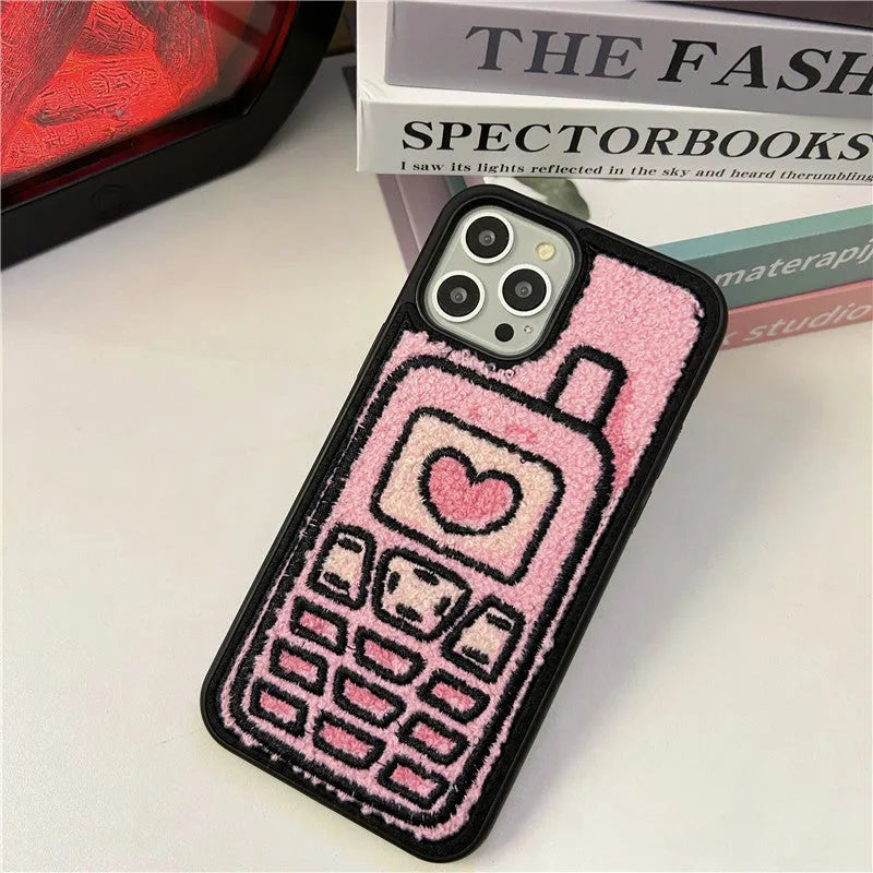 Pink TPU iPhone case with a towel-embroidered pattern, shown fitting an iPhone model.
