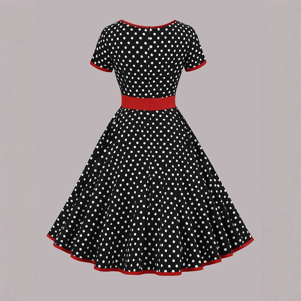 Multicolour polka dot dress with square collar, short sleeves, zip front, and pleated mid-length skirt.