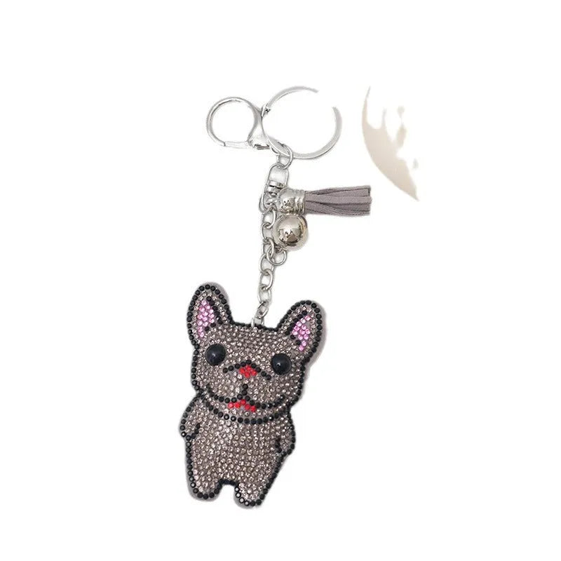 Close-up of a cartoon dog rhinestone keychain charm in alloy, showing sparkling details on a grey background.