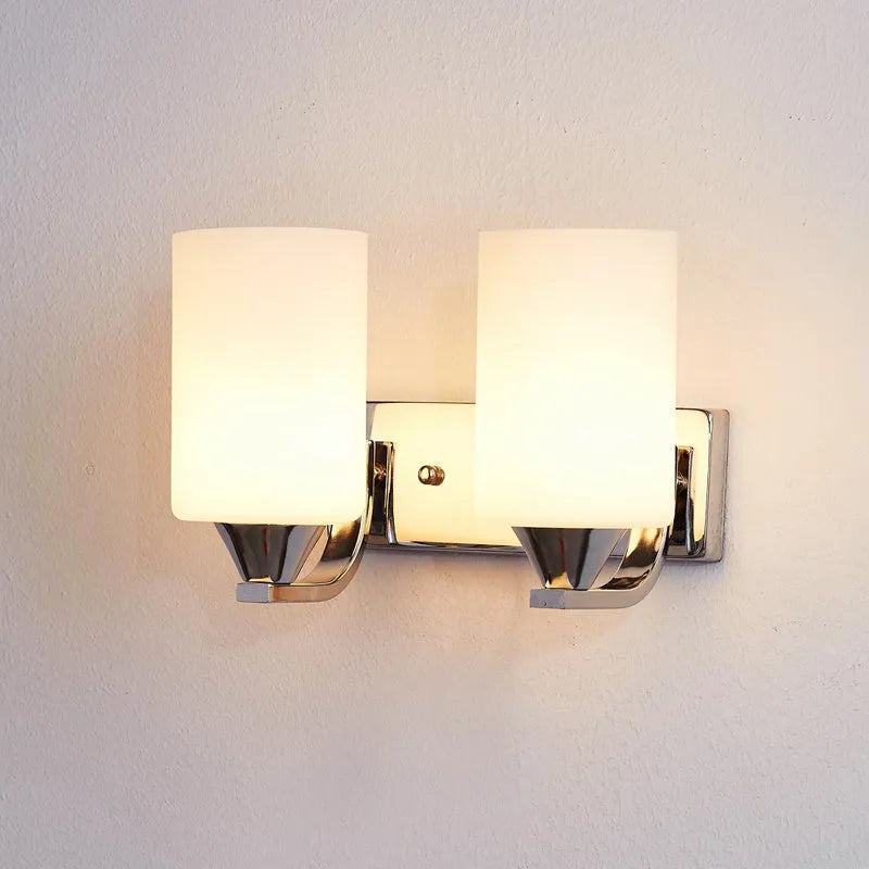 Modern chrome wall lamp with glass lampshade in single head configuration on white wall