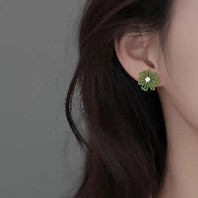 A pair of cartoon-style flower stud earrings in alloy, shown in a two-tone colour option.