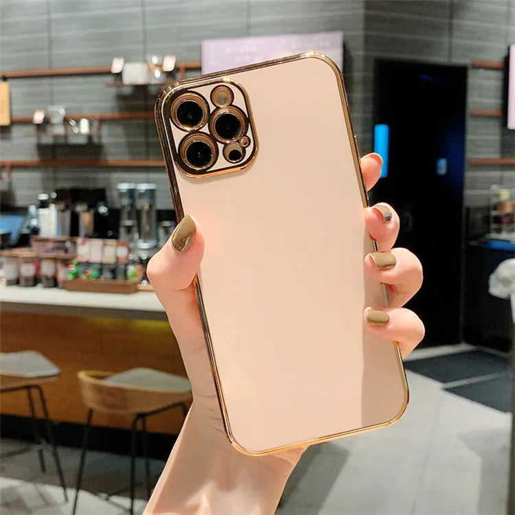 Gold plated iPhone case with silicone stripes for iPhone 13 and 14 models on a table.