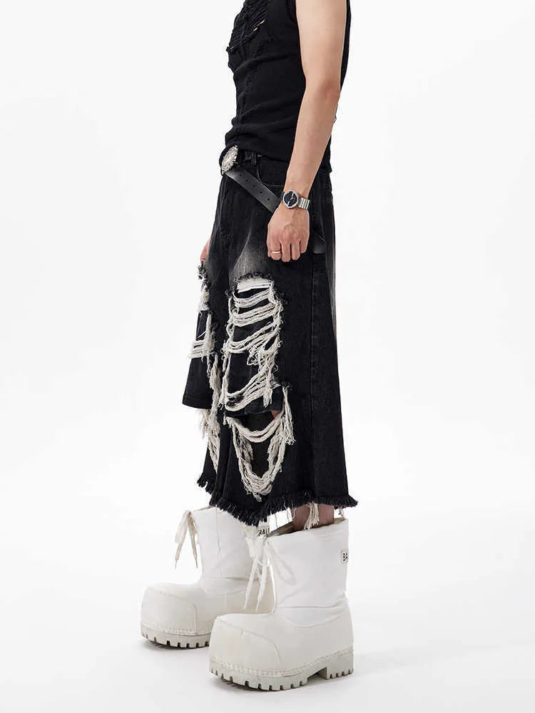 Black cropped wide-leg jeans with ripped patch detail on the leg, showing a mid-high waist and loose fit.