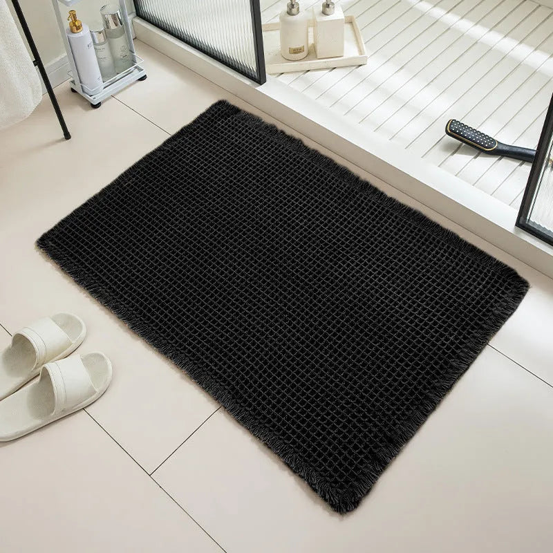 Square checkered-pattern non-slip bathroom carpet in a neutral colour on tiled floor.