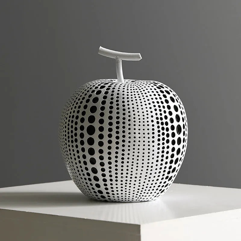Resin decorative sculptures of apples and pears in black, white, orange and blue colours.