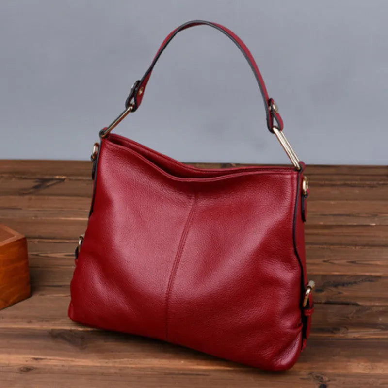 Genuine leather vertical square crossbody bag in black showing outer pocket and structured shape.