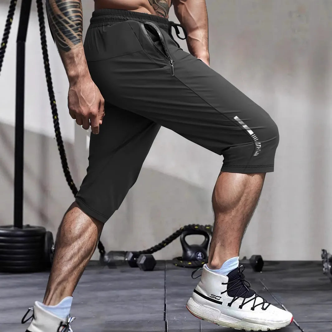 Man wearing grey cropped straight-leg casual sports pants made from quick-dry nylon fabric.