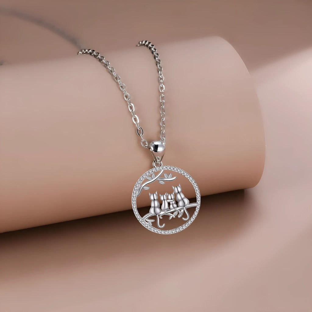 Copper necklace with four kitten pendants on a cross chain, electroplated finish.
