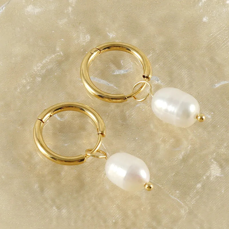 A pair of gold geometric earrings with a pearl detail on a stainless steel post.